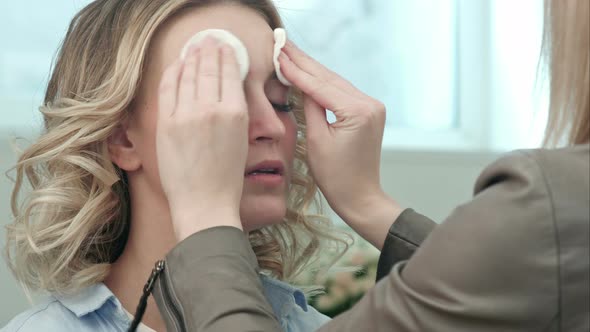 Make-up Artist Preparing and Cleaning Skin of Young Blond Model alt