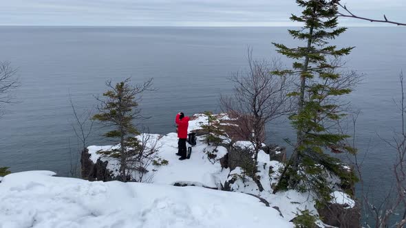 person looking to lake superior standing on a cliff in palisade head, minnesota state parks travel alt