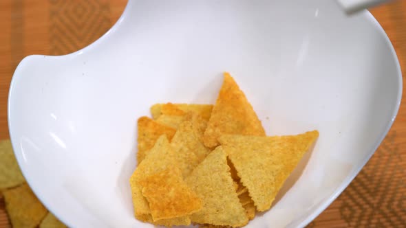 Falling  nachos in a slow rotating plate