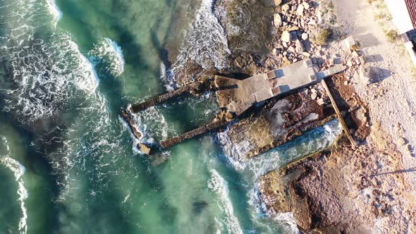 Coastal erosion at Trenc Beach in Mallorca Spain with damaged building foundation pounded by waves, alt