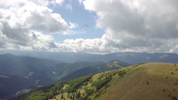 Adrenaline Paraglide Pilots Flying over Green Mountains Landscape alt