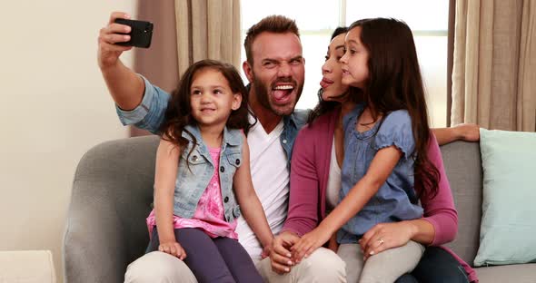 Happy Family Taking Selfie on Sofa alt