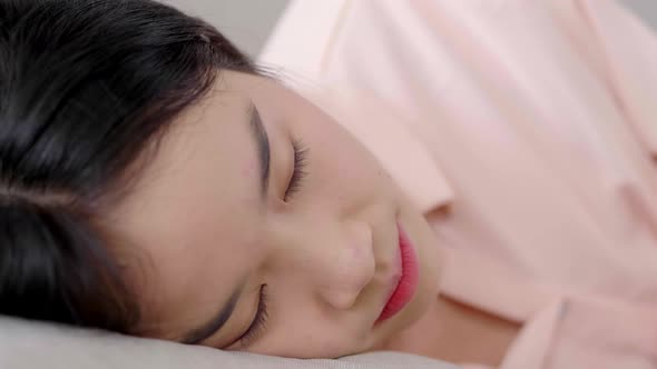 Close up Asian black hair woman lying down on her bed and sleeping at home alt