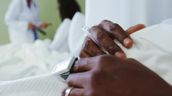 Close-up of pulse oximetry on African american male patient hand in the ward at hospital alt