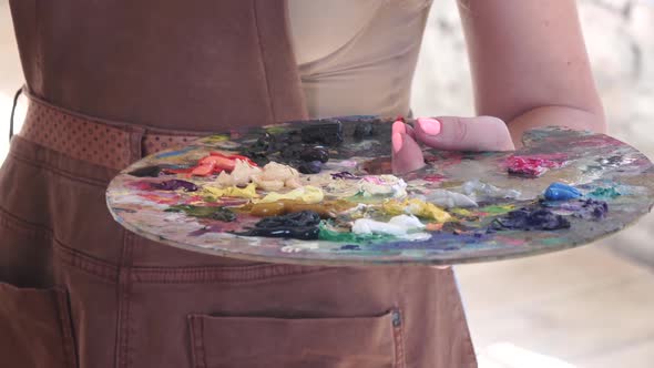 Palette with Different Colors of Oil Paint in Hand Artist alt