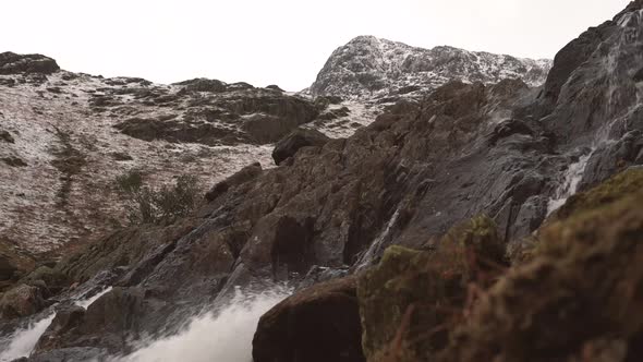 A flowing river beneath a snow covered mountain alt