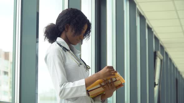 African American Woman Student Intern with a Books in the Hospital. New Modern Fully Functional alt