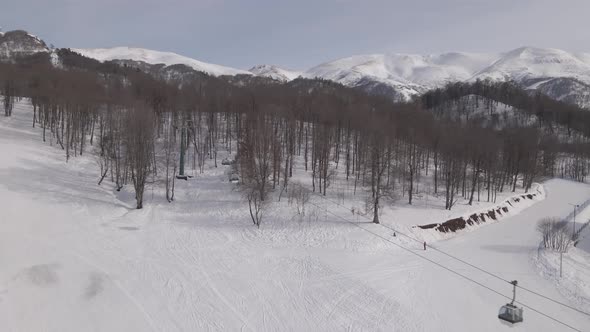 Flying over rope-way with gondolas at mountain resort Crystal Park in Bakuriani. Snowy winter day. alt