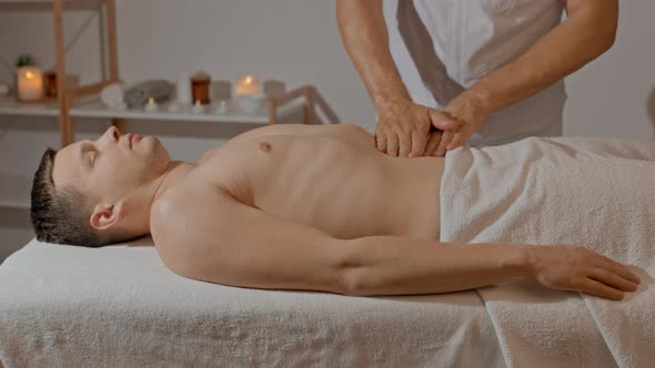 Male Hands Making Massage for Men Abdomen