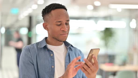 Portrait of Focused Casual African Man Using Smartphone  alt