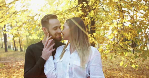 Lovely Couple in Love Stand in Sunny Autumn Park Caresses and Kisses Each Other alt