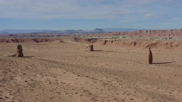 Drone shot flying towards some unique rock pillars in the Southern Utah desert alt
