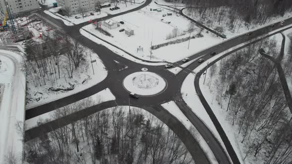 Roundabout with Traffic During Winter Covered with Snow Aerial Rising