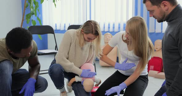 People Learning How to Safe a Life When the Baby is Choked Sitting Together with Instructor During alt