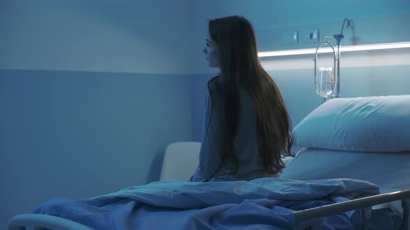 Hospitalized patient sitting on the hospital bed at night