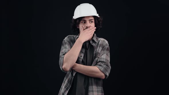 Scared and Shocked Hipster with Curly Hair with His Mouth to His Mouth He Looks with His Eyes alt