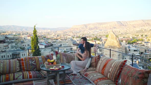 Happy Young Couple During Sunrise Watching Hot Air Balloons in Cappadocia Turkey