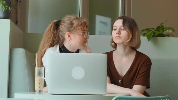 Young Girls Work Remotely in a Cafe on the Summer Terrace alt