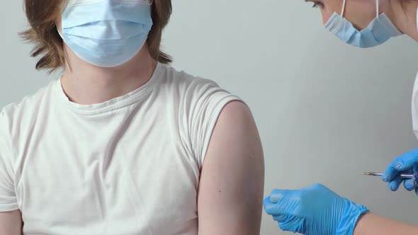 Medical Nurse is Making a Vaccine Injection to a Male Patient Indoor