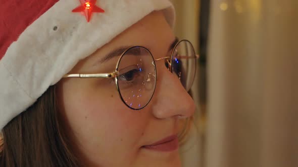 Closeup Portrait of a Beautiful Girl in Glasses Looking at the Christmas Lights