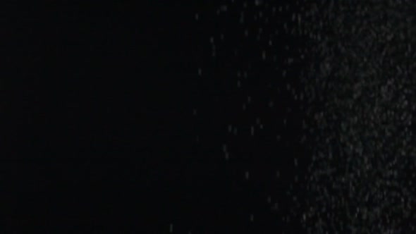 Slow Motion Effect of Powder Dust Snow Particles Falling on Black Background alt
