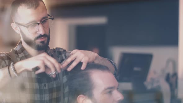 Young Adult Male having haircut in barbershop