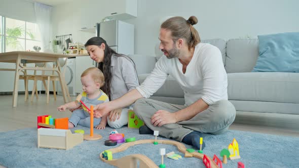Caucasian happy parent, mother and father spend time with young little infant son child in house alt