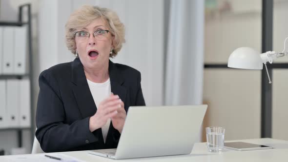Shocked Old Businesswoman with Laptop Looking at Camera alt