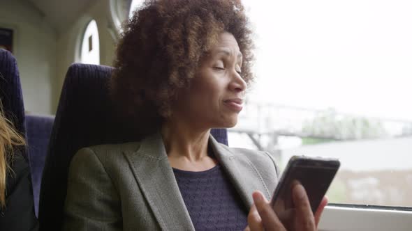 Afro American commuter on her way to work looking at smart phone