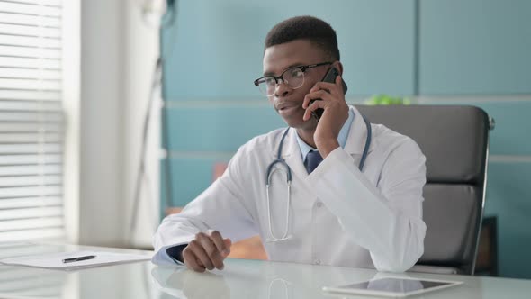 Young African Doctor Talking on Phone in Office alt
