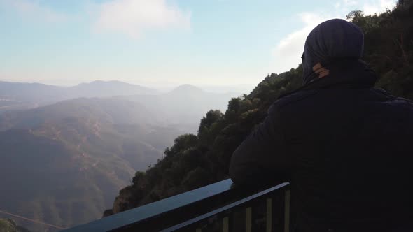 The guy on the observation deck looks at a beautiful view of the mountains