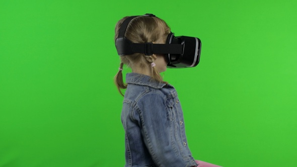 Child Girl Using VR App Helmet To Play Simulation Game, Drawing. Watching Virtual Reality 3d Video alt