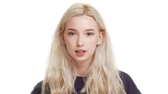 Young Beautiful Caucasian Blonde Teenage Girl Saying What at Camera on White Background in alt