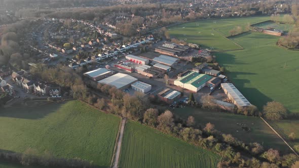 Aerial View Small Industrial Estate And Sports Field On Edge Of Town Suburbs 4K Cine D