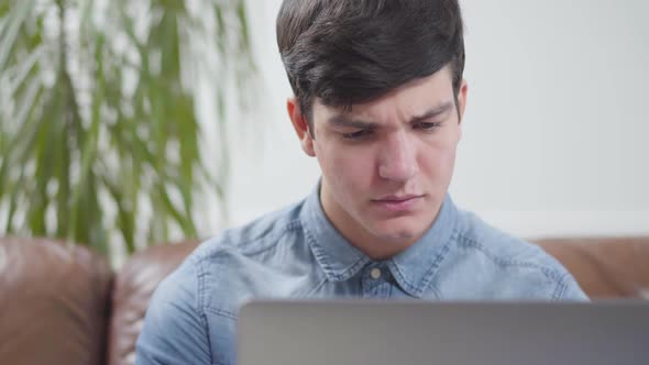 Portrait Handsome Young Man Sitting in Front of Laptop at Home alt