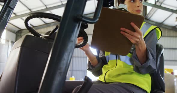 Female technician writing in clipboard alt