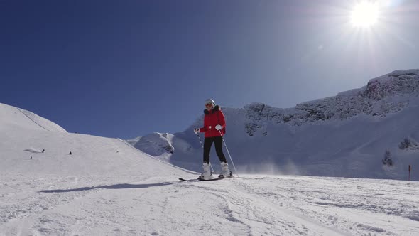 Active Skier Rolls Down Ski Slope In Mountains Against The Background Of The Sun alt