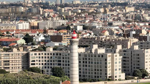 Aerial rotational view over Lighthouse of Leça da Palmeira, Matosinhos with the city behind. alt