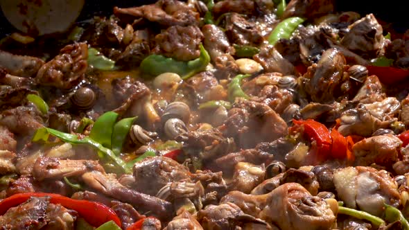 a metal ladle mixes a typical Spanish dish, close up slow motion shot alt