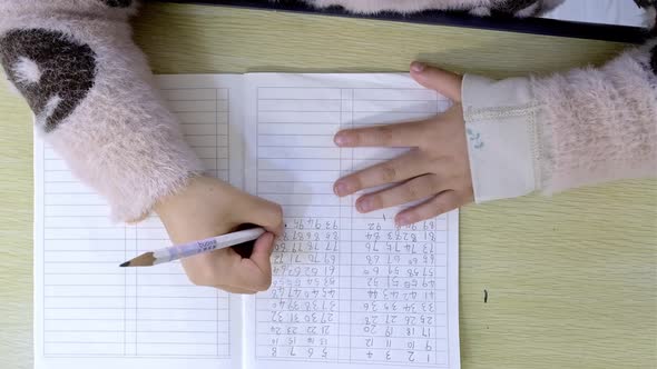 Close Up of Hands of a Girl Student Writing in Composition Book