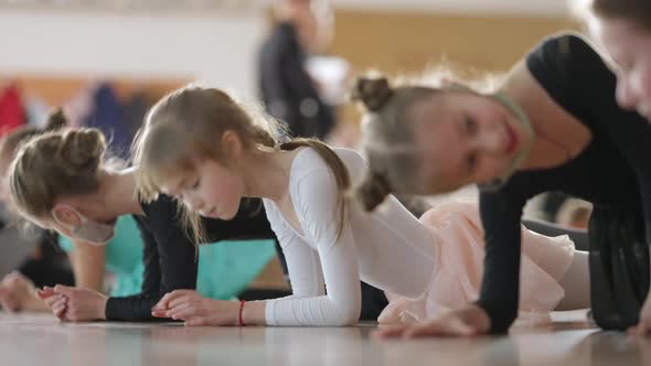 Charming Cute Caucasian Girl Standing in Plank Position with Children in Dance Studio alt
