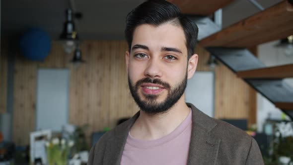 Portrait of Happy Young Man Employee Standing in Office Alone Smiling Looking at Camera alt