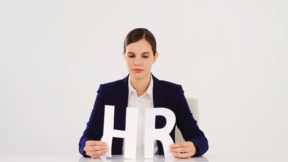 Businesswoman holding paper cut out of HR sign alt