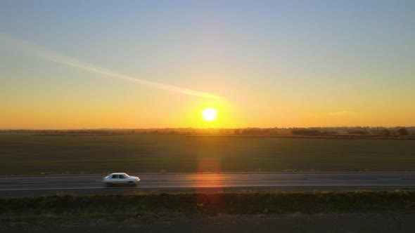Aerial View of Intercity Road with Fast Driving Cars at Sunset alt