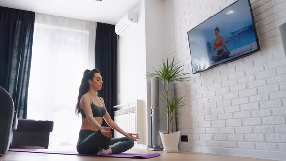 Woman Meditating in Yoga Posture at Home alt