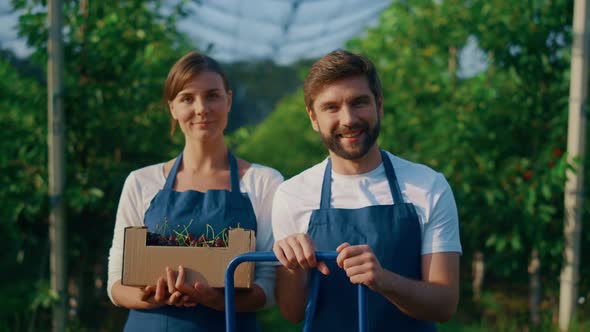 Farmers Team Looking Camera Holding Cherry Berry Crop in Sunny Garden Plantation alt