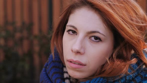 serious confident pretty red haired young woman staring at camera-outdoor alt