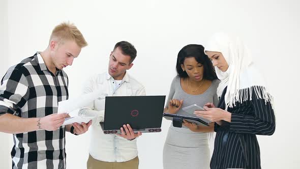 Young Two European Men and Two African American and Muslim Women Using Laptop, Tablet PC alt