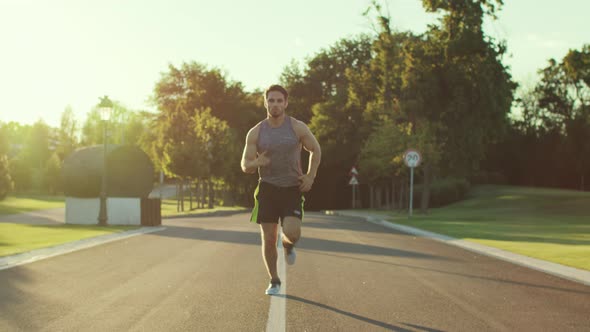 Fitness Man Jogging in Park at Summer Morning. Sport Man Training Run alt