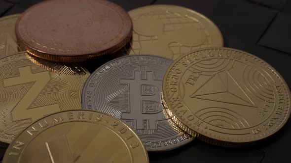 Crypto coins on black background. Hand and Bitcoin BTC Ethereum ETH on a pile of different coins